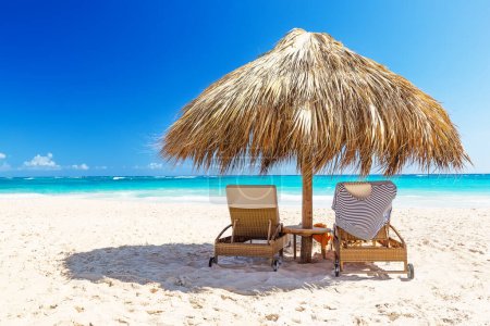 Photo for Beach chairs with umbrella and beautiful sand beach in Punta Cana, Dominican Republic. Tropical white sand beach and turquoise water. Travel summer holiday background concept. - Royalty Free Image
