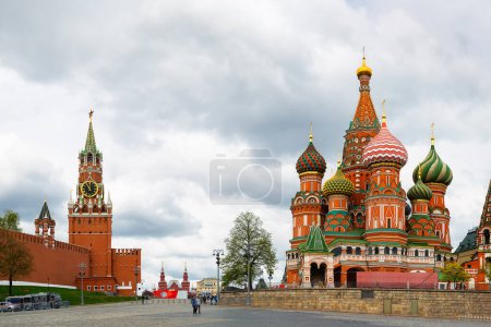 Téléchargez les photos : St. Cathédrale de Basile sur la place Rouge et le Kremlin de Moscou avec la tour Spasskaya sur un fond de ciel nuageux dramatique dans la journée d'été, Moscou, Russie. - en image libre de droit