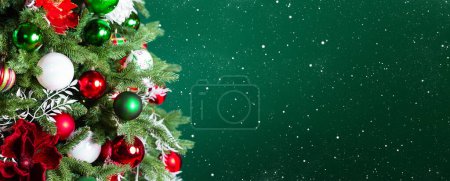 Foto de Árbol de Navidad con adornos, bolas y luces sobre fondo verde oscuro. Feliz Navidad y una feliz tarjeta de felicitación de Año Nuevo. Fondo de vacaciones de invierno. - Imagen libre de derechos