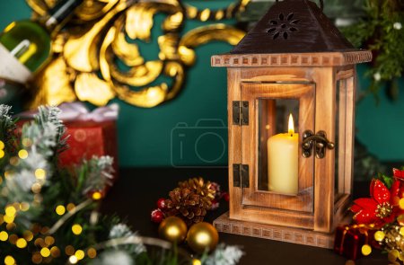 Foto de Diseño de tarjeta de felicitación navideña con escena navideña. Linterna con velas y decoraciones navideñas sobre una vieja mesa de madera - Imagen libre de derechos