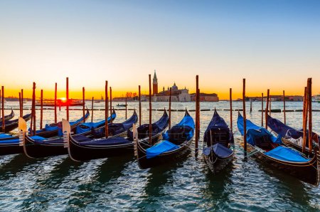 Foto de Gondolas amarradas por la plaza de San Marcos contra la iglesia de San Giorgio di Maggiore al amanecer en Venecia, Italia. - Imagen libre de derechos