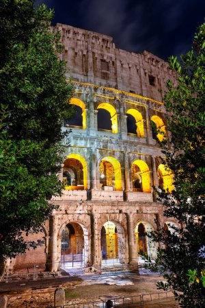 Foto de Arcos de Roma Coliseo (Anfiteador Flavio) iluminado por la noche, Roma, Italia. Increíble exterior del estadio del Coliseo iluminado por la noche en Roma. - Imagen libre de derechos