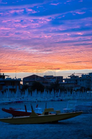 Hermoso amanecer en la playa de Rimini con sombrillas, Italia