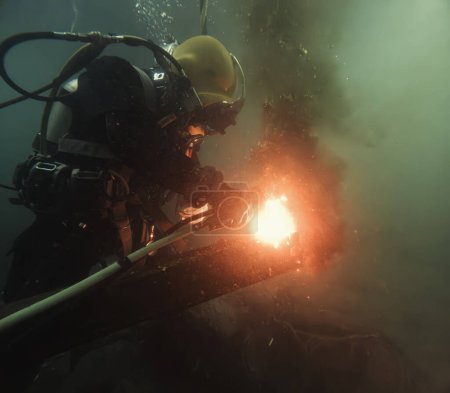 Commercial diver welding and cutting underwater closeup