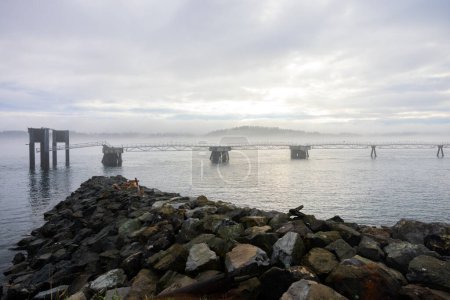 Misty morning over long sea pier closeup