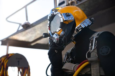 Commercial diver entering water in protective helmet closeup