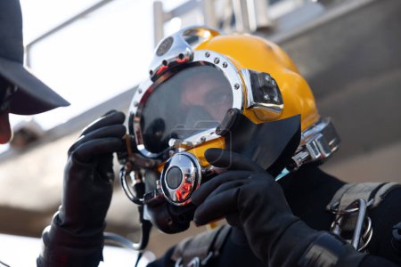 Commercial diver entering water in protective helmet closeup