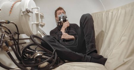 Military man receiving treatment in industrial hyperbaric chamber closeup