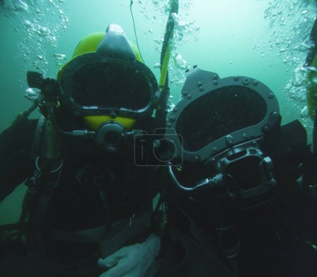 Close up of commercial diver in helmet underwater