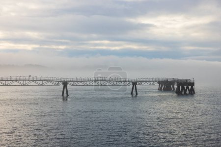 Misty morning over long sea pier closeup