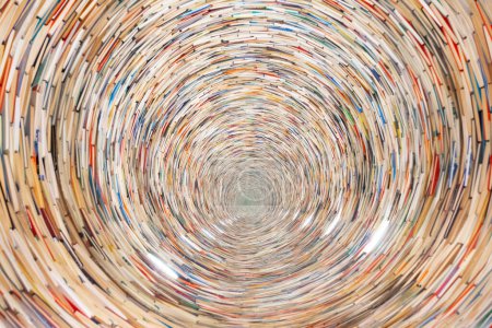 An endless spiraling tunnel of stacked books background