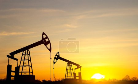 Foto de Silueta de la bomba de aceite. Máquina industrial de petróleo sobre fondo de puesta del sol - Imagen libre de derechos