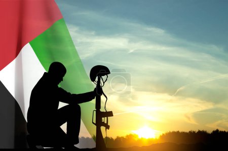 Foto de Silueta de un soldado arrodillado con bandera de los EAU contra el atardecer. Concepto - EAU fiestas nacionales, Día Nacional, Día de la Conmemoración - Imagen libre de derechos