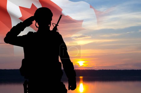 Foto de Silueta de saludo soldado con bandera de Canadá contra el atardecer. Fuerzas Armadas de Canadá - Imagen libre de derechos