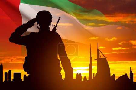 Foto de Silueta de saludo soldado con la bandera de los Emiratos Árabes Unidos contra la puesta del sol. Fuerzas armadas de los Emiratos Árabes Unidos. Concepto para el Día de la Conmemoración, Día de los Mártires, Día Nacional - Imagen libre de derechos