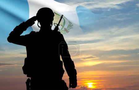 Silueta de soldado con bandera de Guatemala contra el atardecer