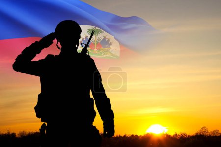 Silueta de un soldado con la bandera de Haití contra el atardecer