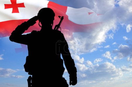 Silhouette of a soldier with the Georgia flag on background of sky