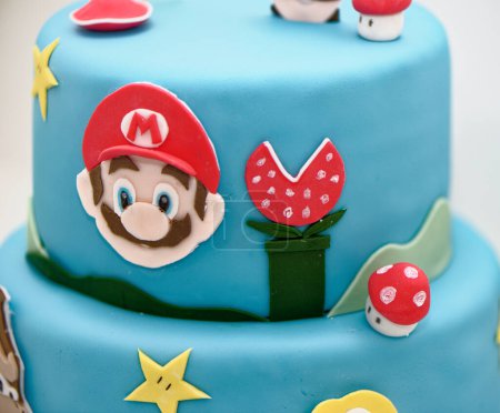 Photo for Super Mario Bros Birthday party cake - Pastel blue birthday cake. Festive cake with a blue marzipan - Royalty Free Image
