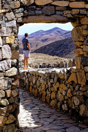 Foto de Hombre caminando por el camino de piedra en el Mirador Astronómico de Sicasumbre, Fuerteventura, Islas Canarias, España - 20 de Septiembre de 2023 - Imagen libre de derechos