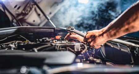 Téléchargez les photos : Auto mechanic working on car engine in mechanics garage. Repair service. authentic close-up shot - selective focus with motion blur - en image libre de droit