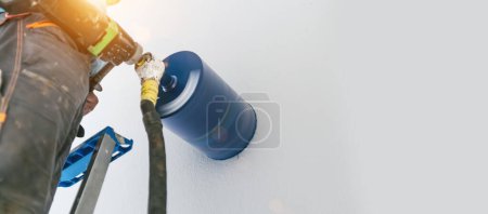 Photo for Male worker preparing a chimney installation for a modern, energy saving heating stove. - Royalty Free Image