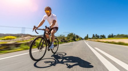 Foto de Hombre Adulto en una bicicleta de carreras escalando la colina en el paisaje marino mediterráneo carretera costera en mallorca isla baleárica. movimiento borroso larga exposición velocidad disparo - Imagen libre de derechos
