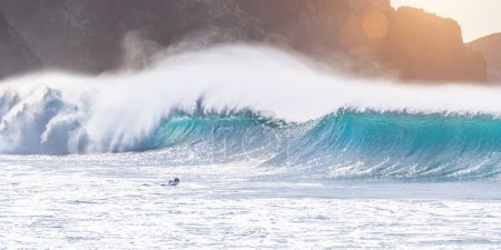 Photo for Young adult surfing on a big wave in the ocean - Royalty Free Image