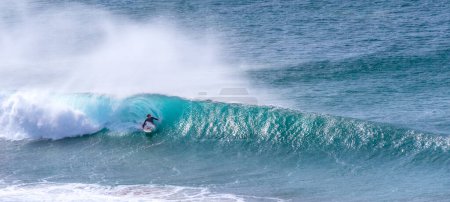 Téléchargez les photos : Jeune adulte surfant sur une grosse vague dans l'océan - en image libre de droit