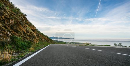 Téléchargez les photos : Mer Méditerranée route côtière dans l'horizon des montagnes en été avec de beaux rayons de soleil lumineux - vue panoramique grand angle - en image libre de droit