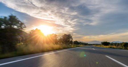 Téléchargez les photos : Longue route de montagne vide à l'horizon par une journée ensoleillée d'été au coucher du soleil lumineux - en image libre de droit