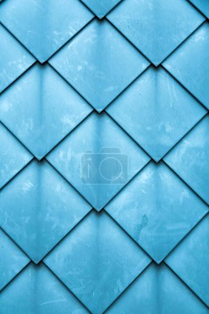 Diamond shaped fish scale tiled wall texture background close up