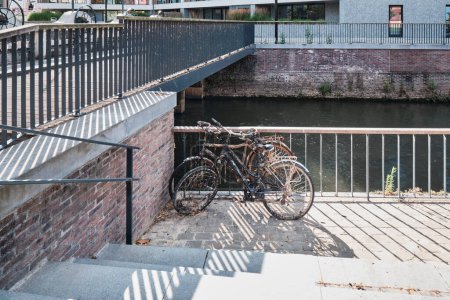 Zwei alte abgestellte Fahrräder am Fluss in der Stadt Leuven, Belgien. 