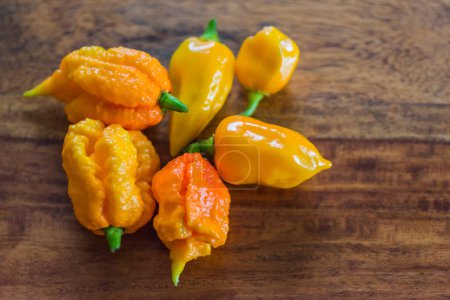 Photo for Many yellow very sharp habaneros on a wooden table detail view - Royalty Free Image