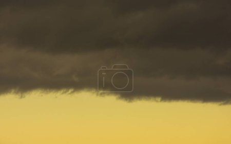 Photo for Dense dark rainclouds and yellow color at the sky during storm - Royalty Free Image
