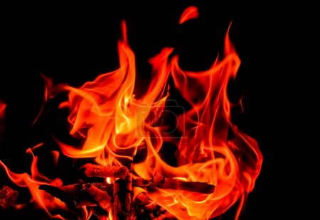 Foto de Fuego rojo brillante con muchas llamas con fondo negro en el verano - Imagen libre de derechos