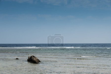 Foto de Roca única en el arrecife de coral en el mar con cielo azul de vacaciones - Imagen libre de derechos