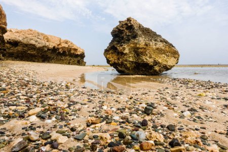 Foto de Enorme roca de coral que yace en la playa con muchas piedras de colores y corales durante el reflujo en Egipto - Imagen libre de derechos