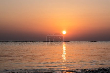 warme, strahlende Sonne am Roten Meer mit Reflexionen im Wasser bei Sonnenaufgang in Ägypten