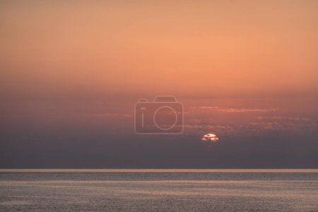 sun peeks out from clouds during sunrise at the red sea in egypt