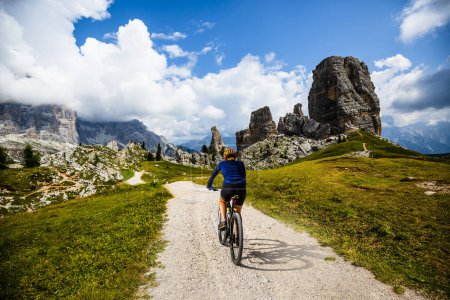 Photo for Woman ride electric mountain bikes in the Dolomites in Italy. Mountain biking adventure on beautiful mountain trails. - Royalty Free Image