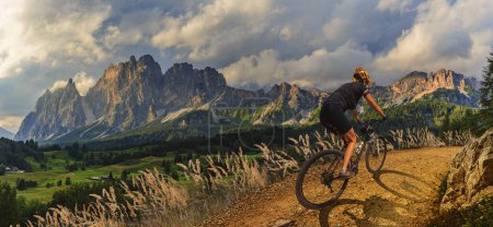 Frau fährt Elektro-Mountainbike in den Dolomiten in Italien. Mountainbike-Abenteuer auf schönen Mountainbike-Trails.