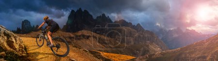 Photo for Woman ride electric mountain bikes in the Dolomites in Italy. Mountain biking adventure on beautiful mountain trails. - Royalty Free Image