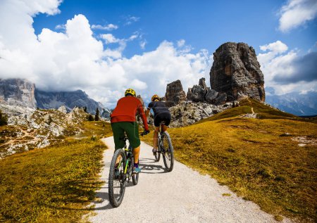 Téléchargez les photos : Un homme et une femme font du VTT électrique dans les Dolomites en Italie. VTT aventure sur de beaux sentiers de montagne. - en image libre de droit