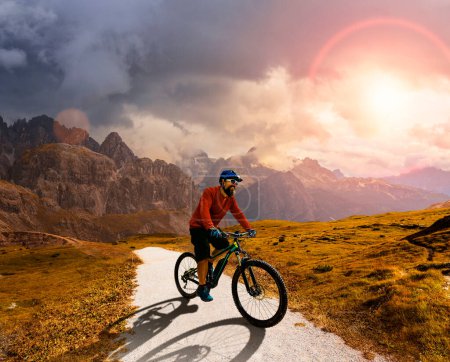 Photo for A man ride electric mountain bikes in the Dolomites in Italy. Mountain biking adventure on beautiful mountain trails. - Royalty Free Image