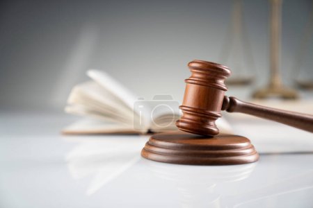 Concept de droit et justice. Cabinet de juge marteau et code juridique sur bureau blanc.
