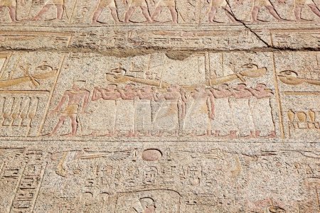 Téléchargez les photos : Figures sculptées et géroglyphes au complexe du temple Karnak à Louxor, en Égypte. Le complexe comprend un vaste mélange de temples, de pylônes, de chapelles et d'autres bâtiments. La construction a commencé pendant le règne de Senusret I, qui a régné 1971-1926 BCE. - en image libre de droit