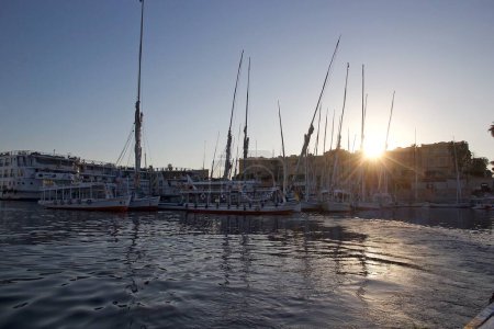 Téléchargez les photos : Coucher de soleil sur le Nil à Louxor, Egypte, avec des bateaux et des feluccas - en image libre de droit