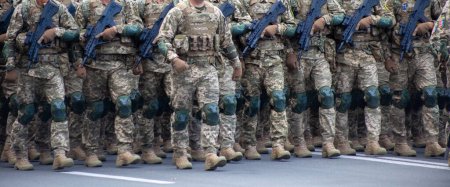 Militärangehörige marschieren in einer Parade mit Waffen. Pixel-Uniform. Soldatenbeine. Kriegshintergrund. Stiefel von Spezialeinheiten und Infanterie. Männer gehen an die Macht