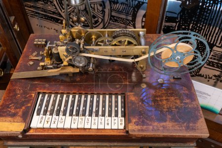 Foto de Un viejo telégrafo de madera con un teclado y una cinta. Los primeros medios de comunicación. Aparato vintage. Polonia, Varsovia - 28 de julio de 2023. - Imagen libre de derechos